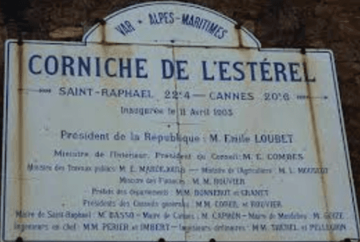 A post sign in front of a red mountain